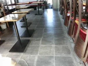 下地調整した床に塩ビタイルを貼り、床の不陸が目立たない様子