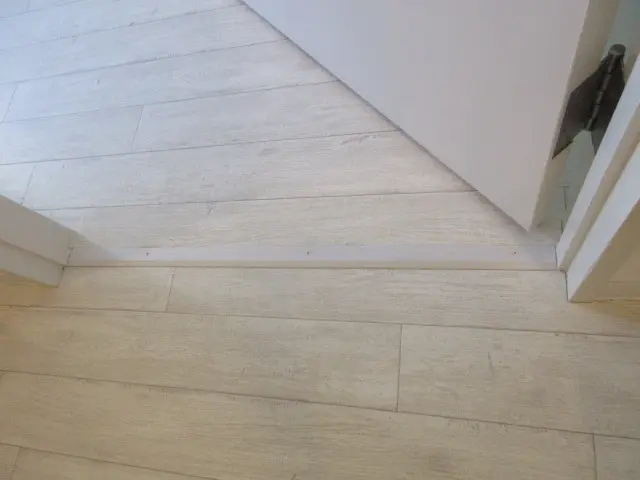 廊下と部屋の境にへの字押さえを取付けた様子