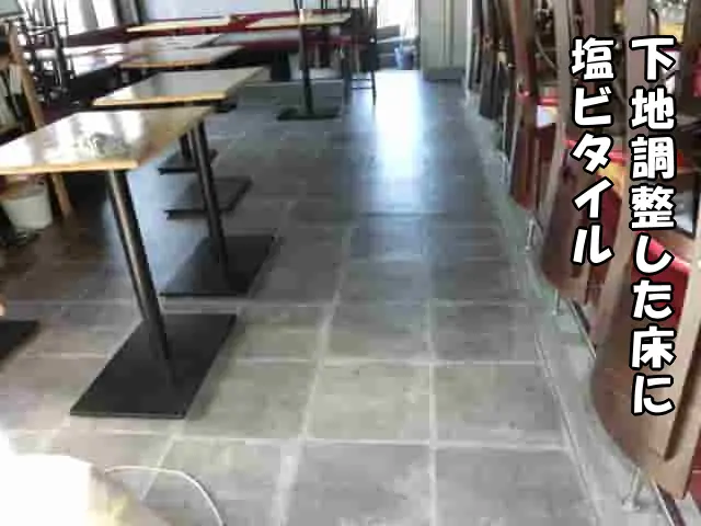 下地調整した床に塩ビタイルを貼り、床の不陸が目立たない様子
